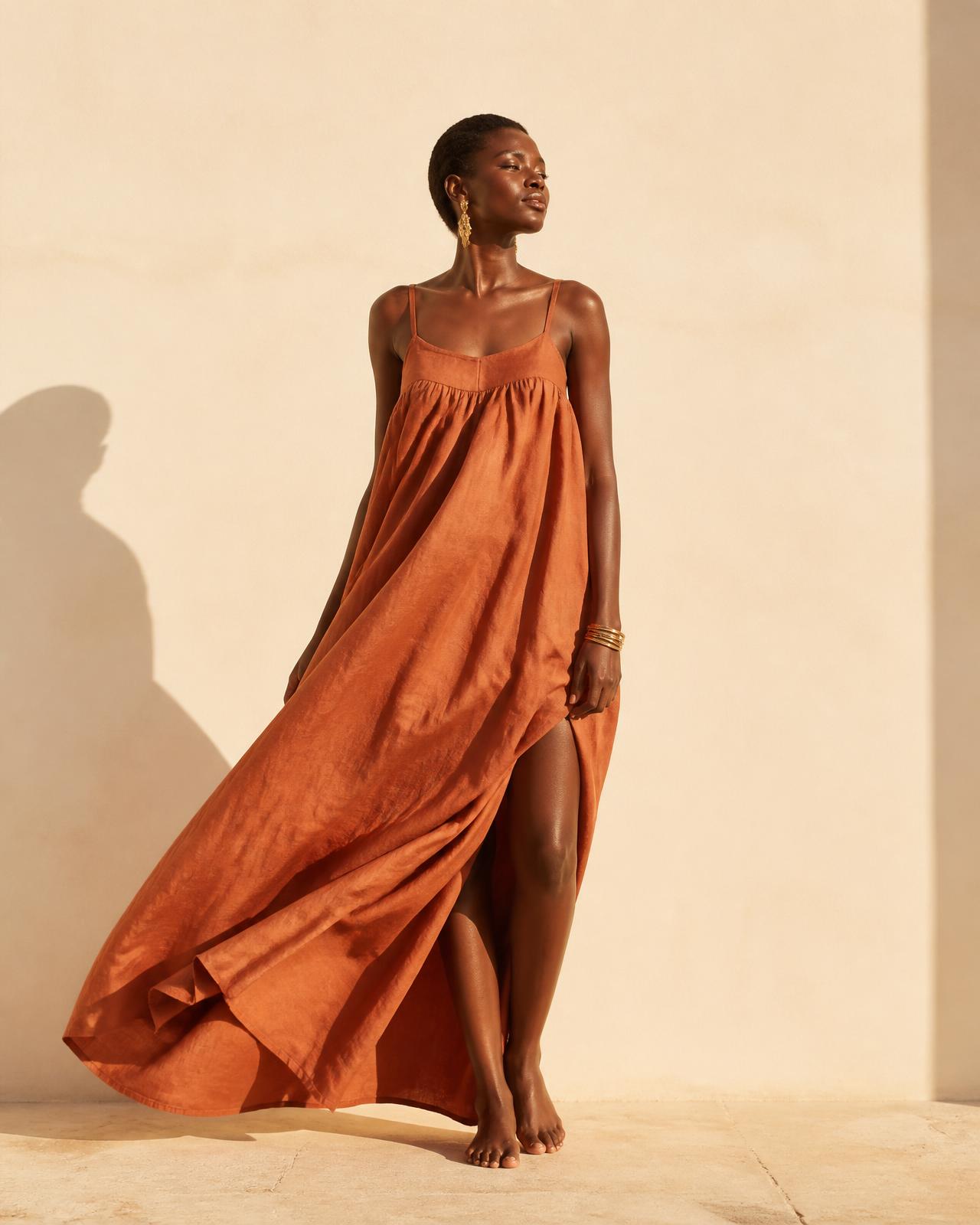 Robe fluide en lin terracotta sous la lumière dorée